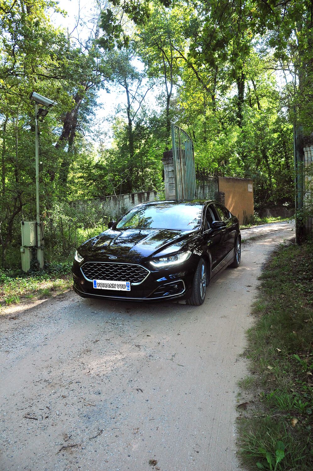 La berline de Yohann, plaque « Yohann VTC », devant un portail provençal