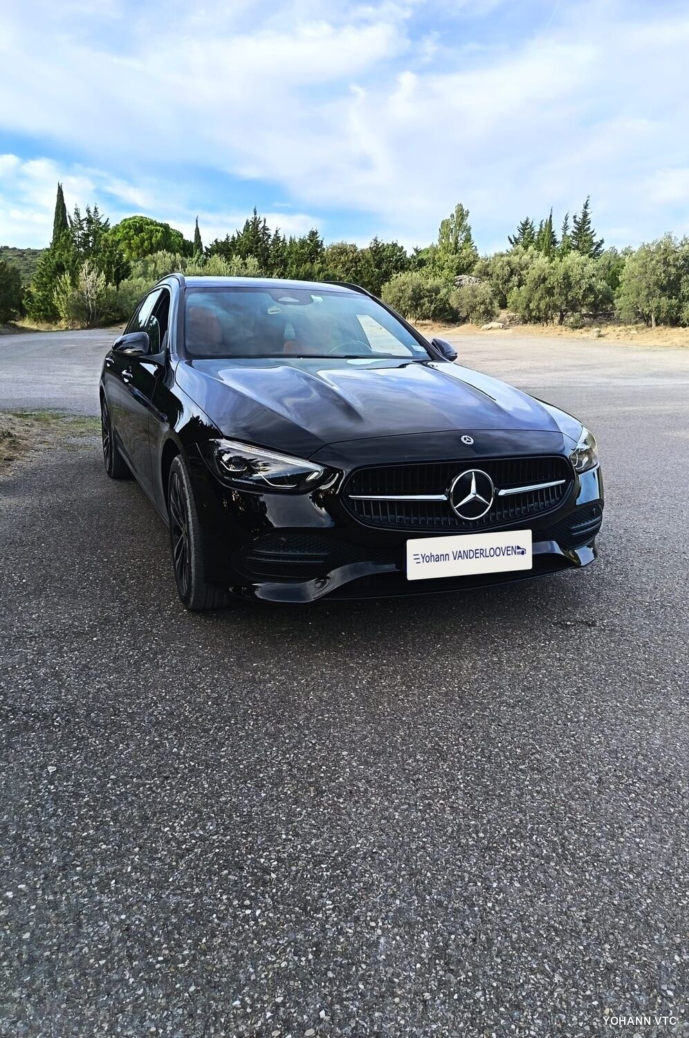 La Mercedes Classe C break de Yohann, de face, sur une route bordée de cyprès