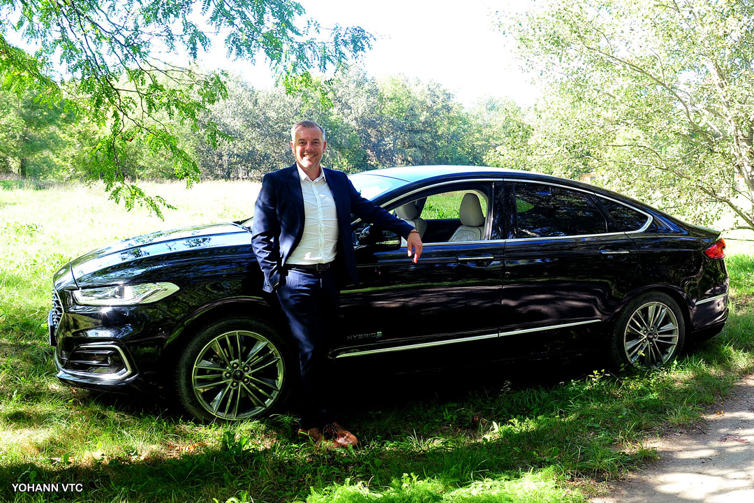 Yohann, chauffeur privé, devant sa berline